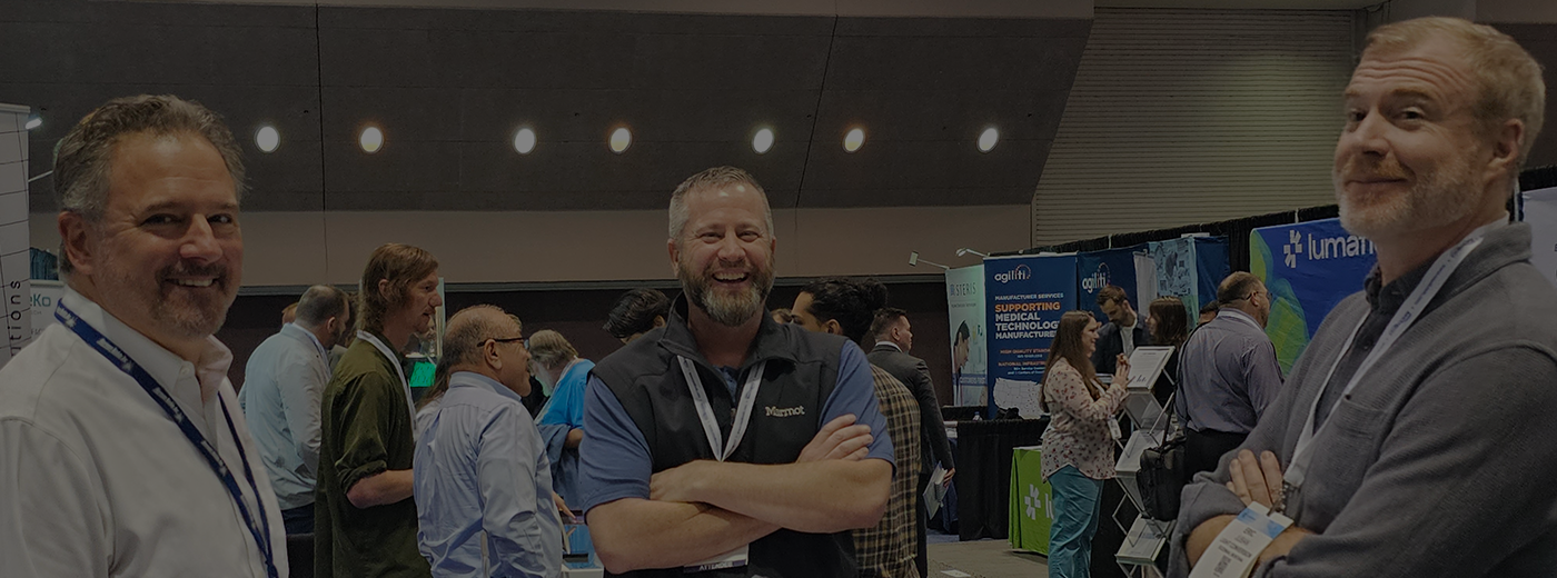 Three smiling men at the MEDevice Silicon Valley expo floor