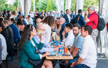 a photo of people earing lunch in picnic tables 